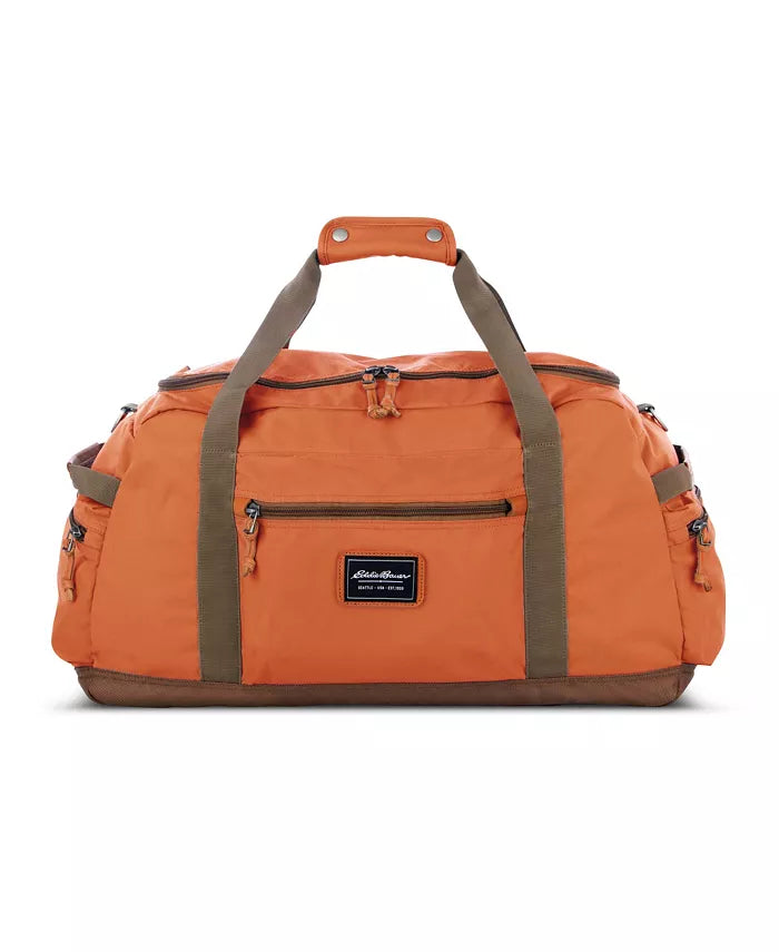 The Eddie Bauer Bygone Recycled 45L Duffel in terracotta, made from recycled nylon, features brown handles and trim, multiple zippered pockets, and a durable design label on the front.