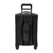 The Briggs & Riley Baseline Essential 22 Carry-On Expandable Spinner in black features a retractable handle, four wheels, a front pocket, garment folder for organized packing, and a small removable pouch below the handle for travel convenience and mobility.