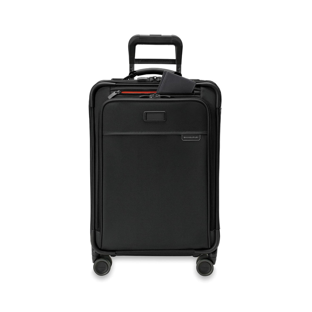 The Briggs & Riley Baseline Essential 22 Carry-On soft sided suitcase with four wheels and a retractable handle, featuring a front zipper pocket, luggage tag, and CX expansion for added space.